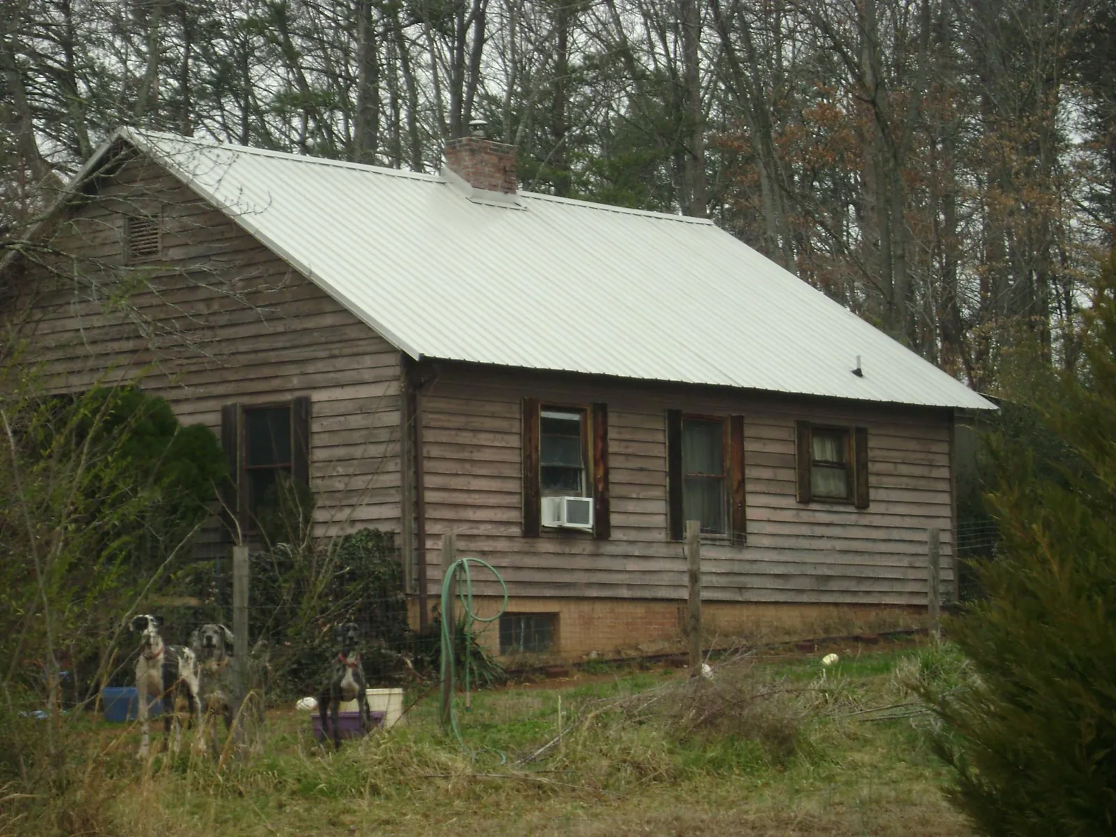 White metal roof on an old wood sided farmhouse, from a Metal Roof Installation job in Mc Donald