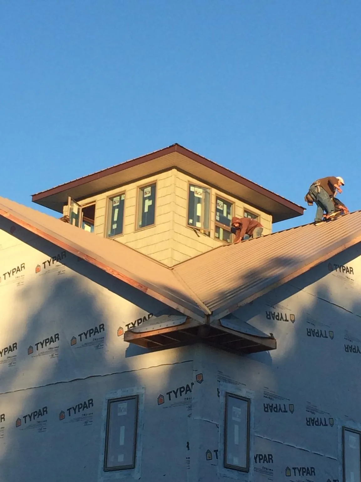 Roofers working around a rooftop cupola on a new metal roof at sunset — Roof Waterproofing in Mc Donald by Roofing Brothers